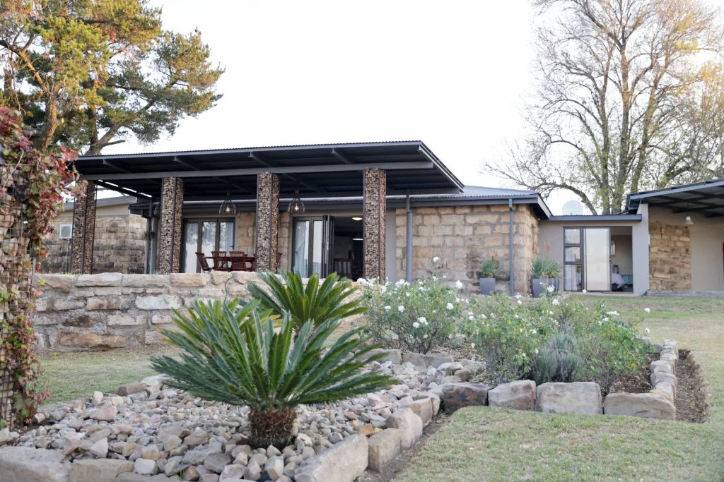 Beautifully landscaped garden in front of a high-end stone hunting lodge in the Free State.