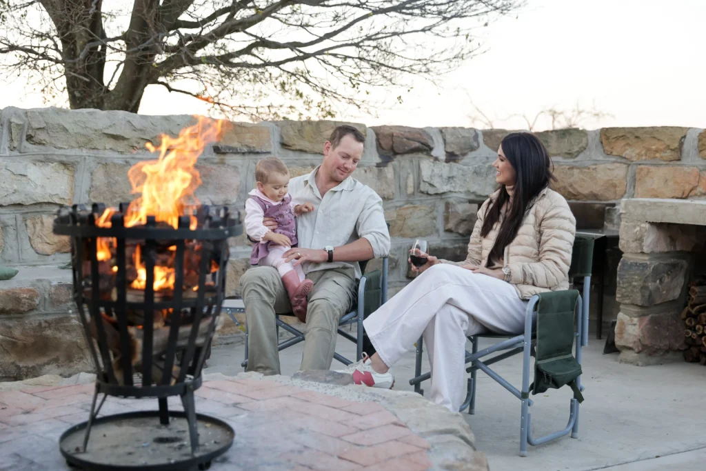 Family sharing a moment by the fire at a luxurious Free State hunting retreat, highlighting comfort and connection.