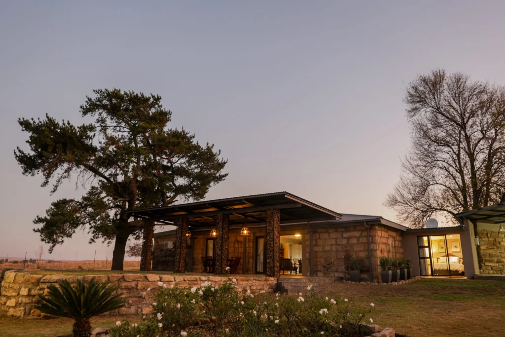 Elegant stone hunting lodge in the Free State at sunset, offering premium comfort and serene bushveld surroundings.