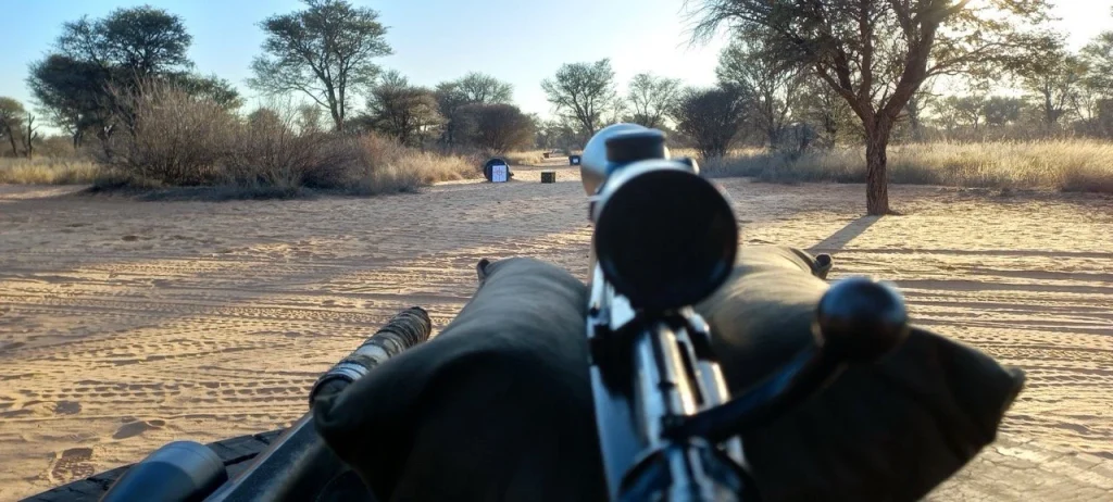 View through a scoped hunting rifle aimed at distant shooting targets in the open Kalahari bushveld.
